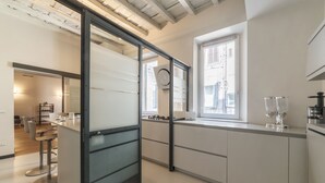 A modern kitchen with a sliding glass door, a bar area, and a window providing natural light.