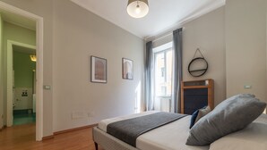 Un dormitorio con una cama grande, un aparador de madera y una ventana con cortinas.