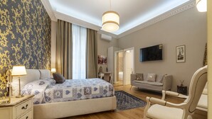 Un dormitorio con cama, mesita de noche, lámpara y una silla.