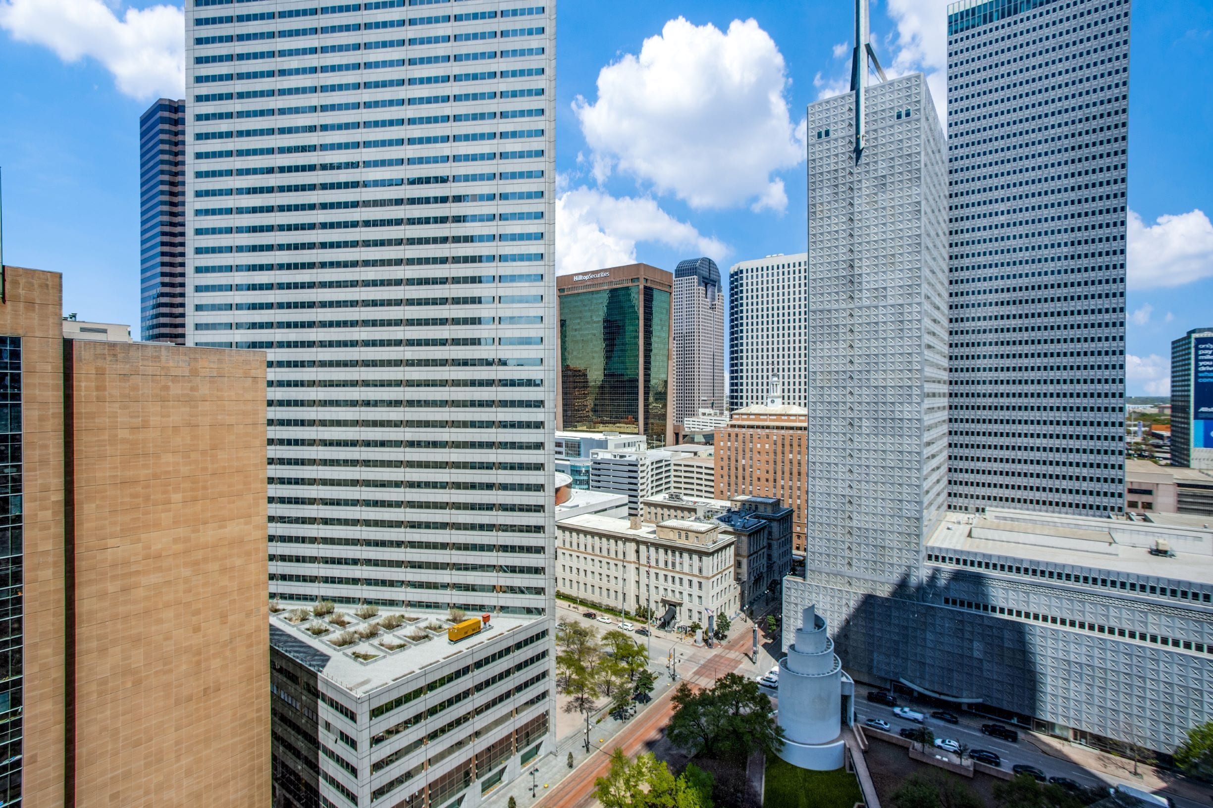 A cityscape with modern high-rise buildings, including a prominent skyscraper with a unique design.