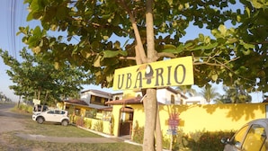 A yellow building with a sign reading "UBA RIO" and a car parked in front. - Pousada Uba-Rio Porto de Galinhas (Ipojuca)