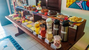 A buffet table with various food items and beverages. - Pousada Uba-Rio Porto de Galinhas (Ipojuca)