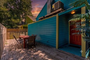 A blue house with a red door, a wooden deck with chairs, and a wooden fence. - Charming 3BR Treme home with patio. Sleeps 6, Wi-Fi, laundry, walk to French Quarter & Fair Grounds (New Orleans)