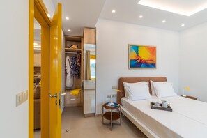Una habitación de hotel con cama, mesita de noche y un cuadro en la pared.