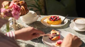 Una mesa con un pastel, una tetera y una taza de café.