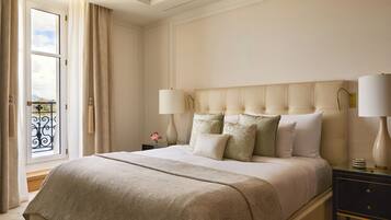 A neatly made bed with a tufted headboard, two bedside lamps, and a nightstand with a lamp.