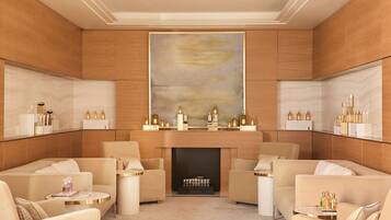 A luxurious living room with a fireplace, comfortable seating, and a large abstract painting on the wall.