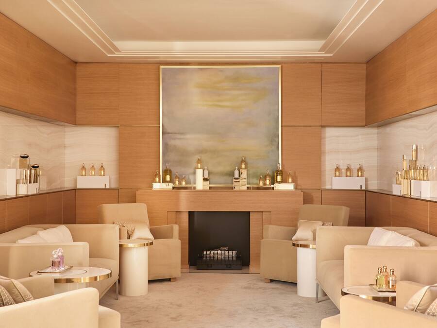 Un salon luxueux avec une cheminée, des fauteuils confortables et un grand tableau abstrait accroché au mur.