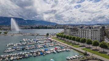 Un port de plaisance où sont amarrés de nombreux bateaux, une fontaine et un grand bâtiment à l’architecture classique.