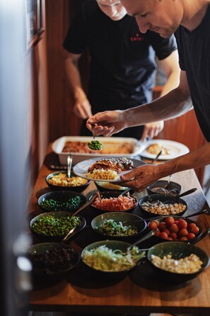 A dining table with various dishes and a person serving food.