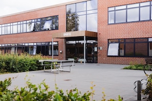 A brick building with a sign reading "SPORTEL" and a covered entrance.