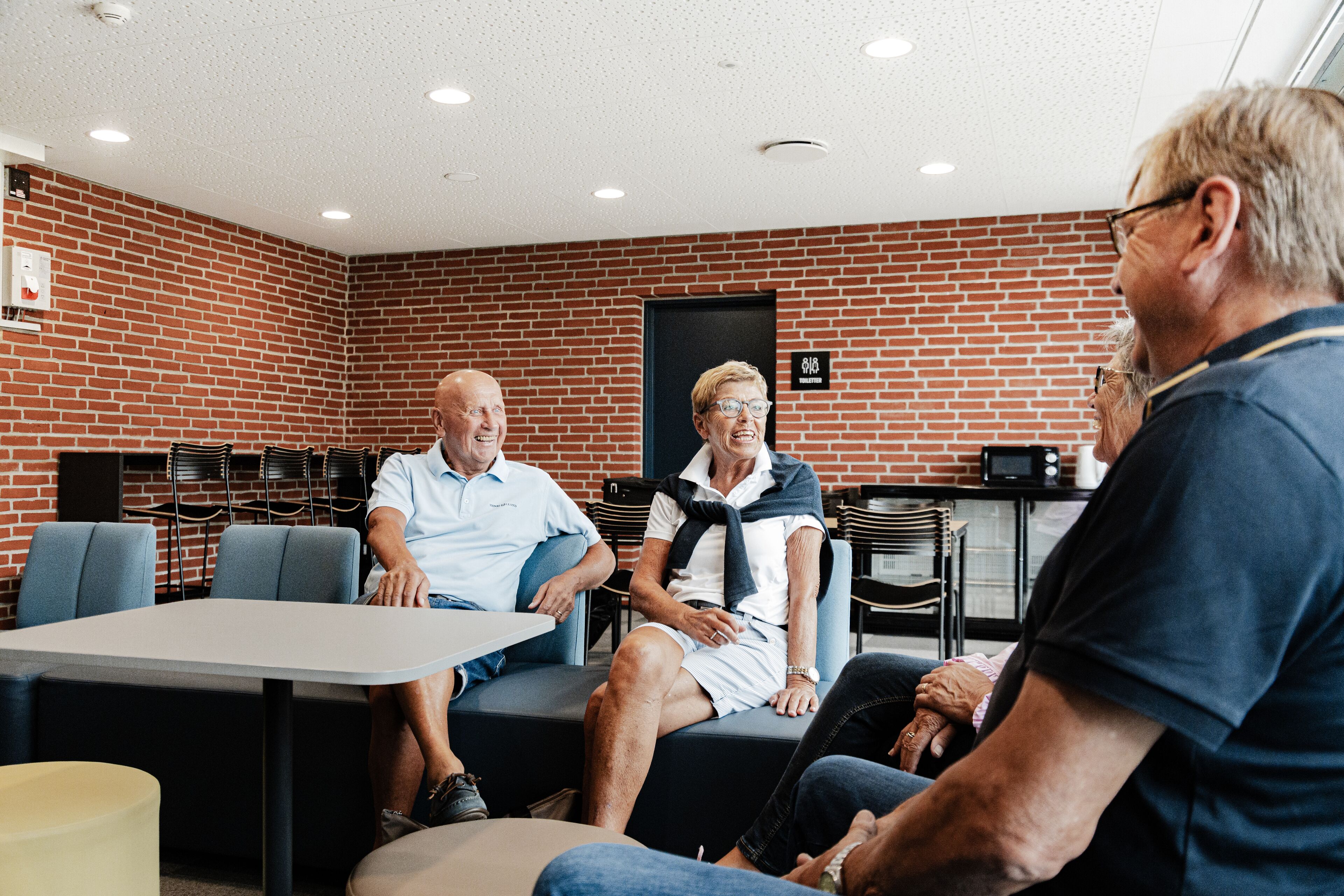 A room with brick walls, a table, and chairs.