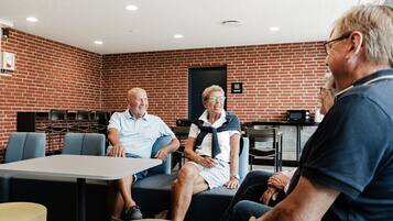 A room with brick walls, a table, and chairs.