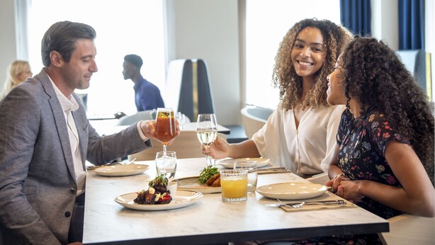 A dining table with plates of food, glasses, and a menu. - Leonardo Hotel Bristol City (Bristol)