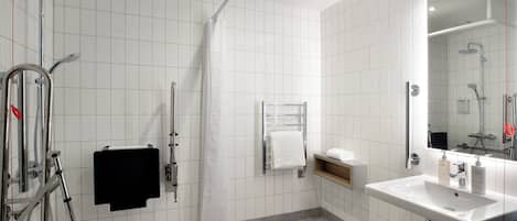 A modern bathroom with a shower, a sink, and a mirror.