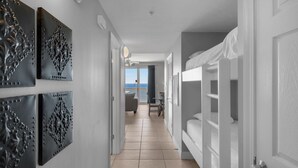 Un pasillo con vistas al mar, una litera y paneles decorativos en la pared.