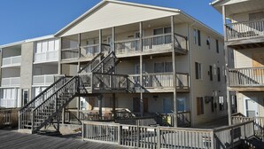 Ein mehrstöckiges Hotel mit Balkonen, einer zentralen Treppe und einer Holzterrasse.