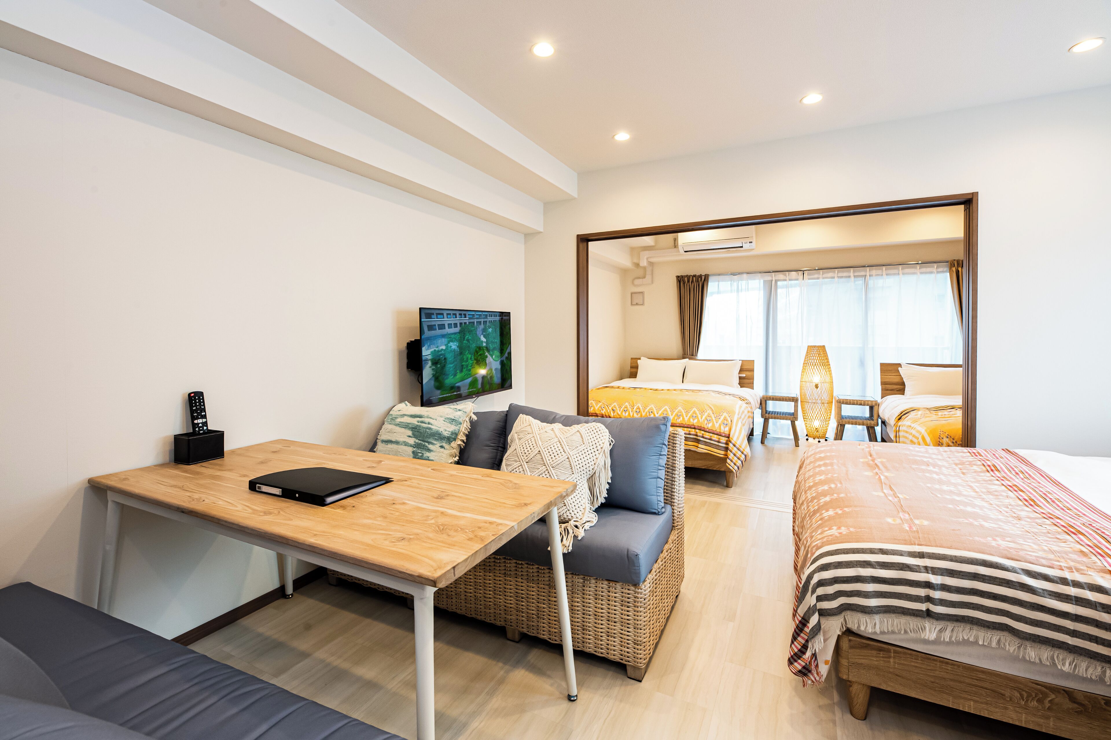 Una habitación de hotel moderna con un escritorio de madera, un sofá, una cama y un televisor.