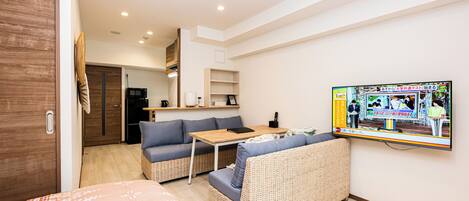 A modern room with a sofa, a small table, and a TV mounted on the wall.
