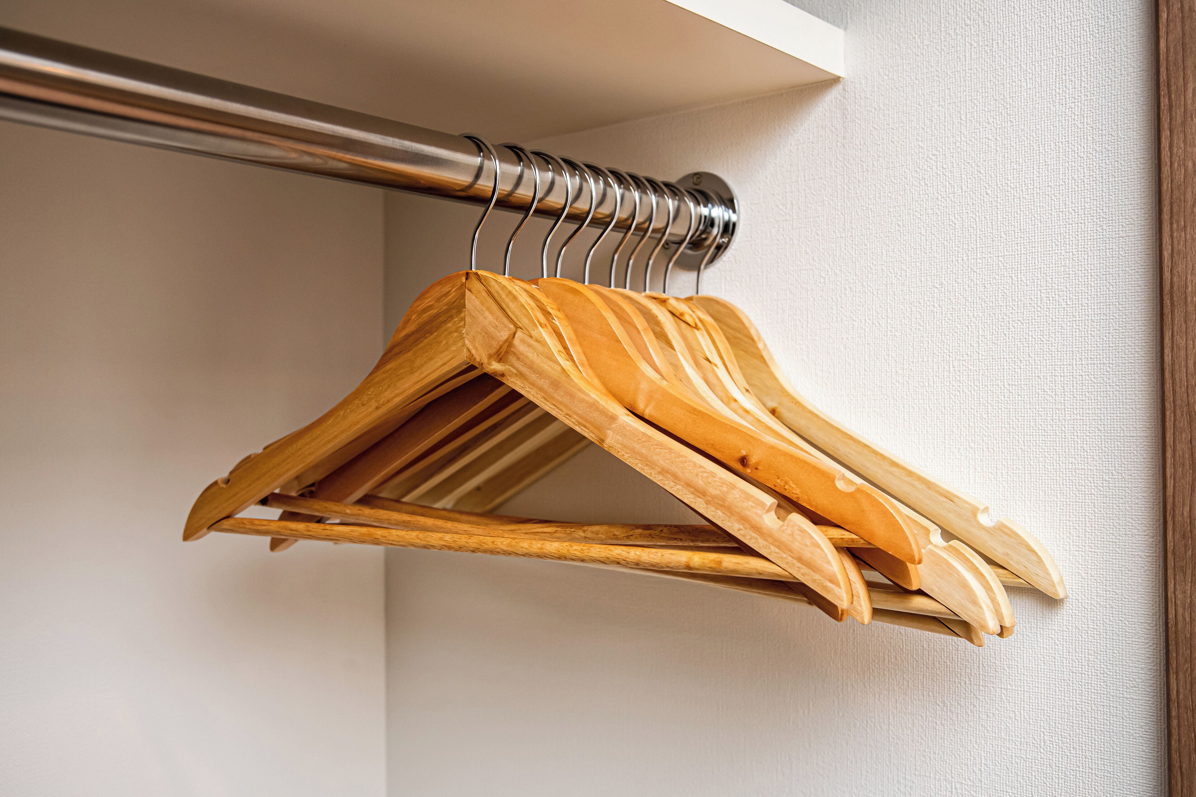 A wooden hanger rack against a wall.