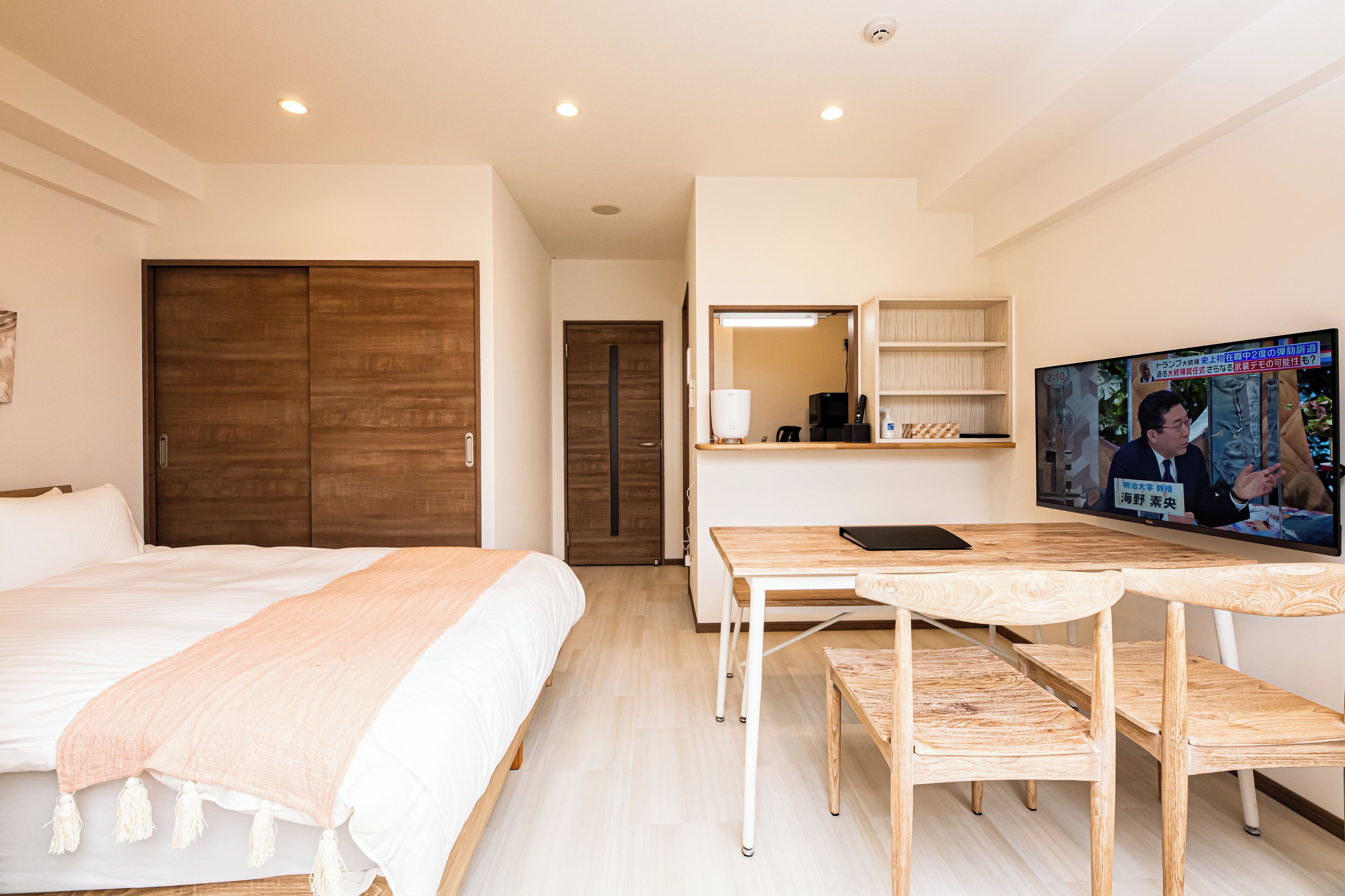 Une chambre d’hôtel moderne équipée d’un grand lit, d’un bureau en bois, d’une télévision et d’une armoire.