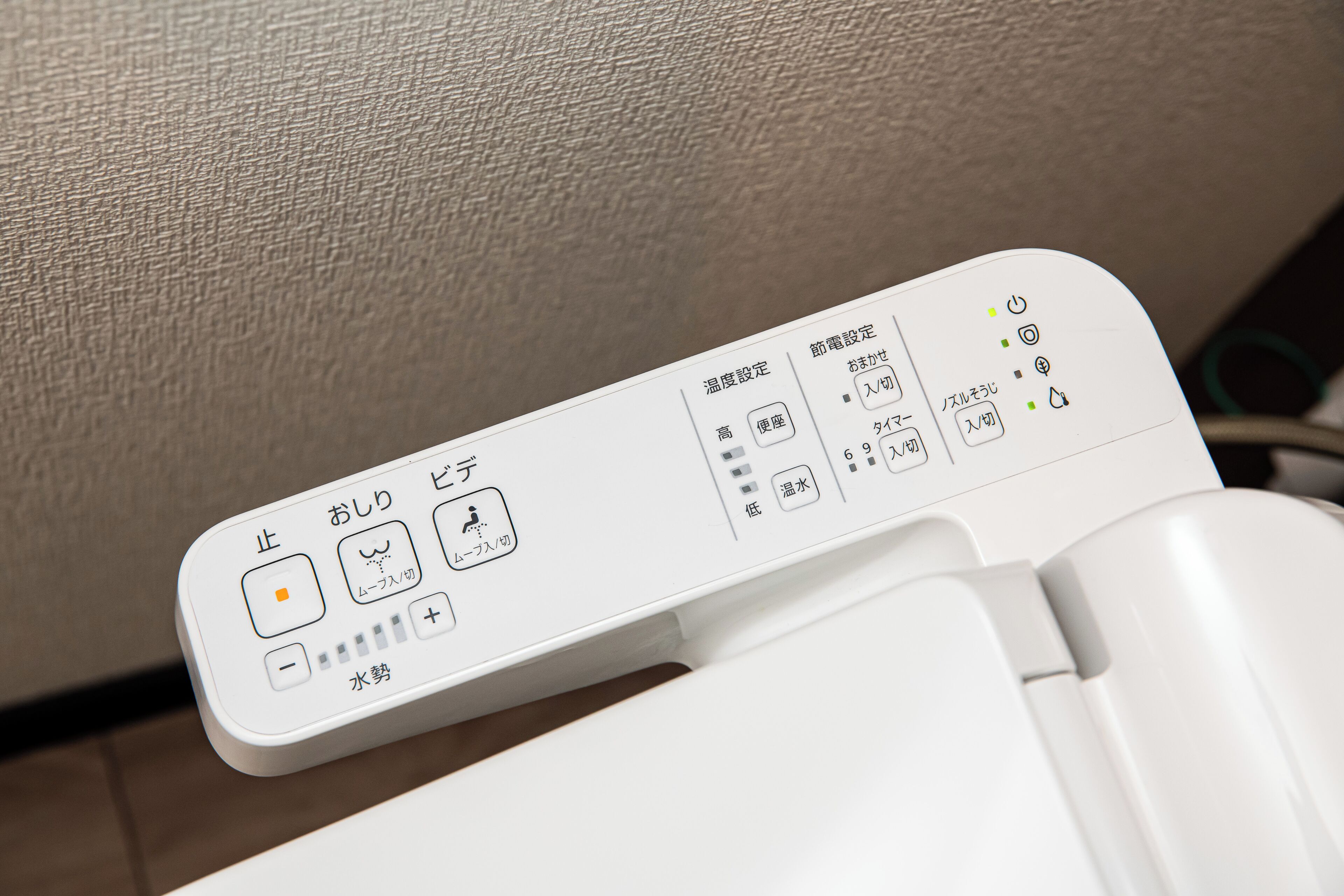 Painel de controle com texto e símbolos em japonês, provavelmente para um aparelho ou eletrodoméstico.