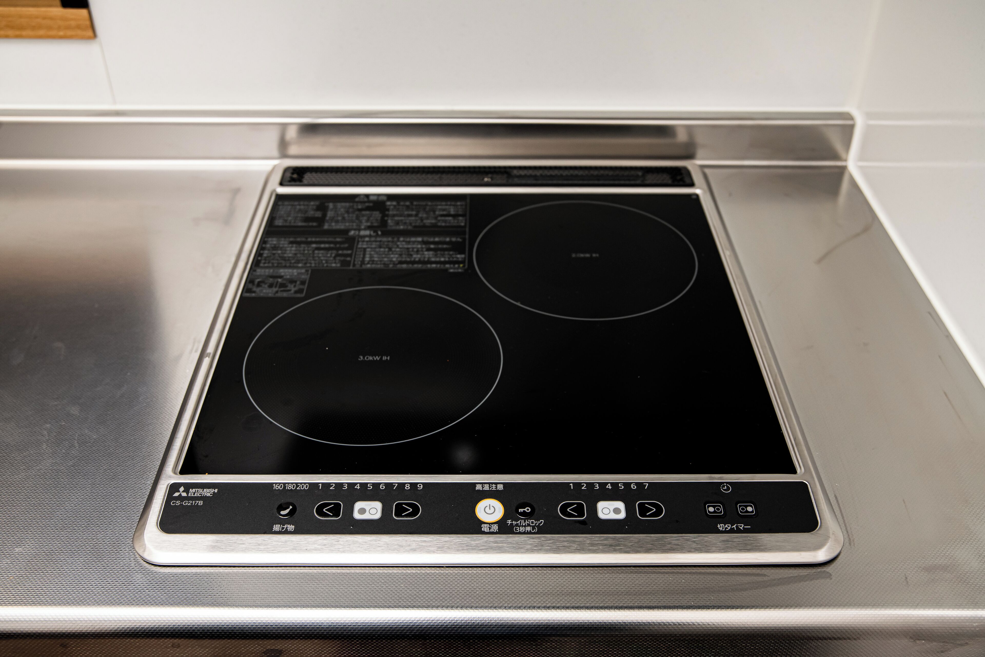 A stainless steel induction cooktop with a digital control panel.