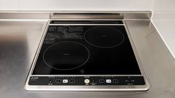 A stainless steel induction cooktop with a digital control panel.