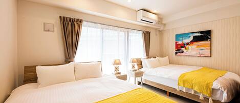 A hotel room with two beds, a painting on the wall, and an air conditioning unit.