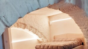 Un dormitorio con cama, suelo de madera y una estructura de techo abovedada original.