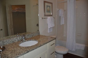 A bathroom with a granite countertop sink, a toilet, and a shower area. - Lucaya 4 Bedrooms 3 Baths Townhome! (Kissimmee)