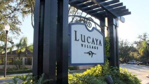 Segnaletica per Lucaya Village, con struttura a pergola e vegetazione circostante.