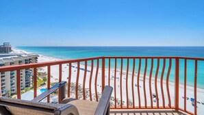 A balcony with a view of a beach and ocean.