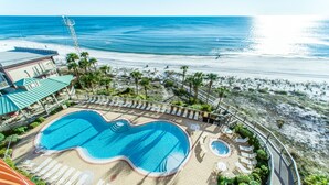 A resort pool with a view of the beach and ocean.