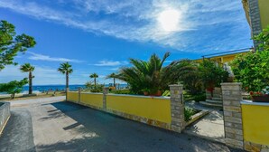 A coastal property with a swimming pool, yellow walls, and a view of the sea. - Beachfront Holiday Apartment Inga Yellow with sea view (Vir)