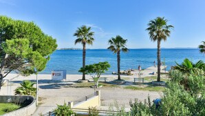 A beach with palm trees, a sign with 'VIR' on it, and a clear blue sky. - Beachfront Holiday Apartment Inga Yellow with sea view (Vir)