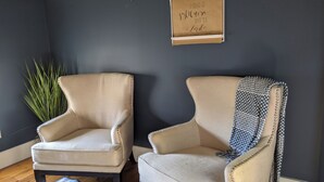 Two armchairs with a dark wall and a decorative banner in the background.