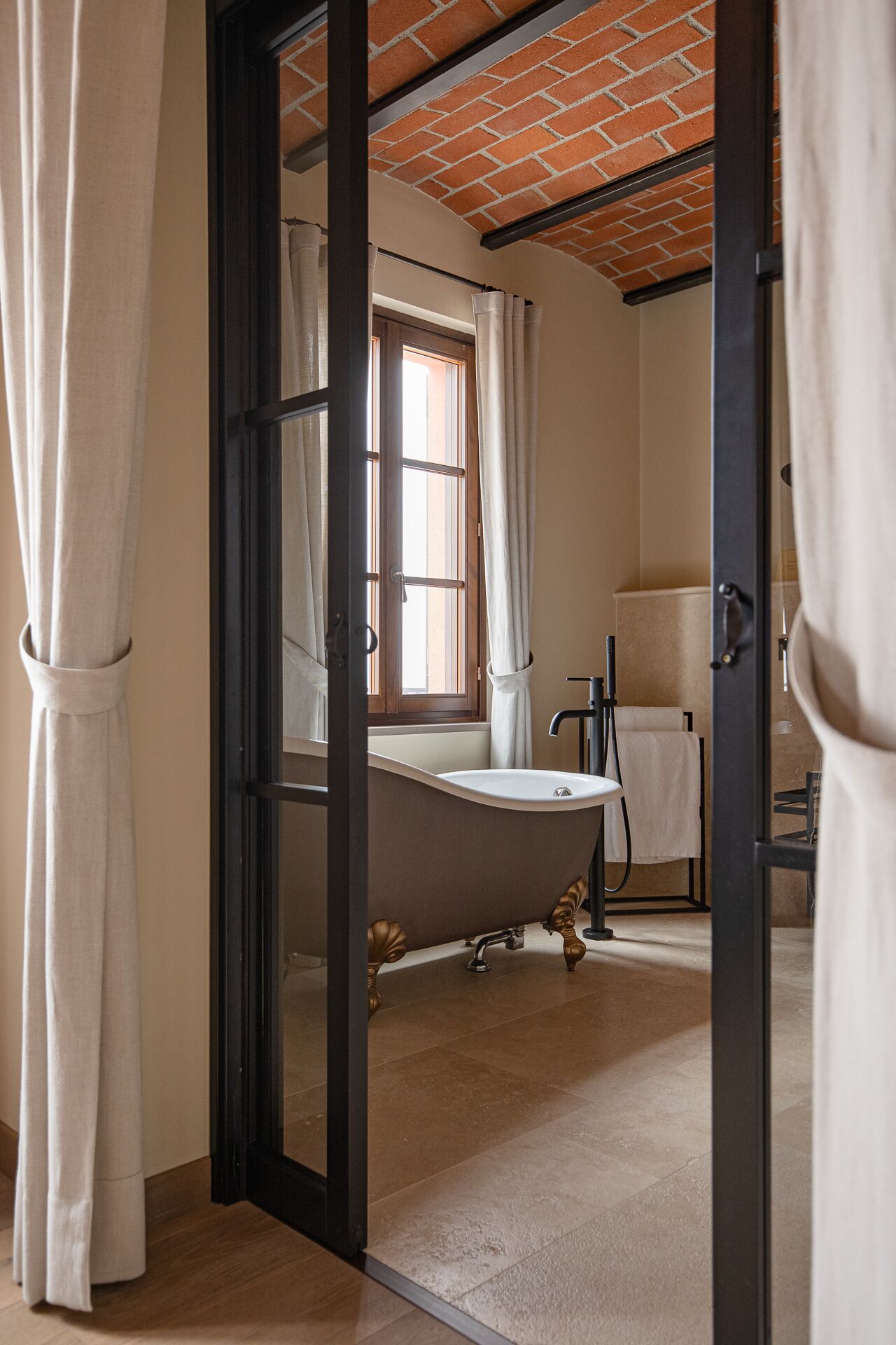 Ein Badezimmer mit Fenster, Waschbecken und Handtuchhalter.