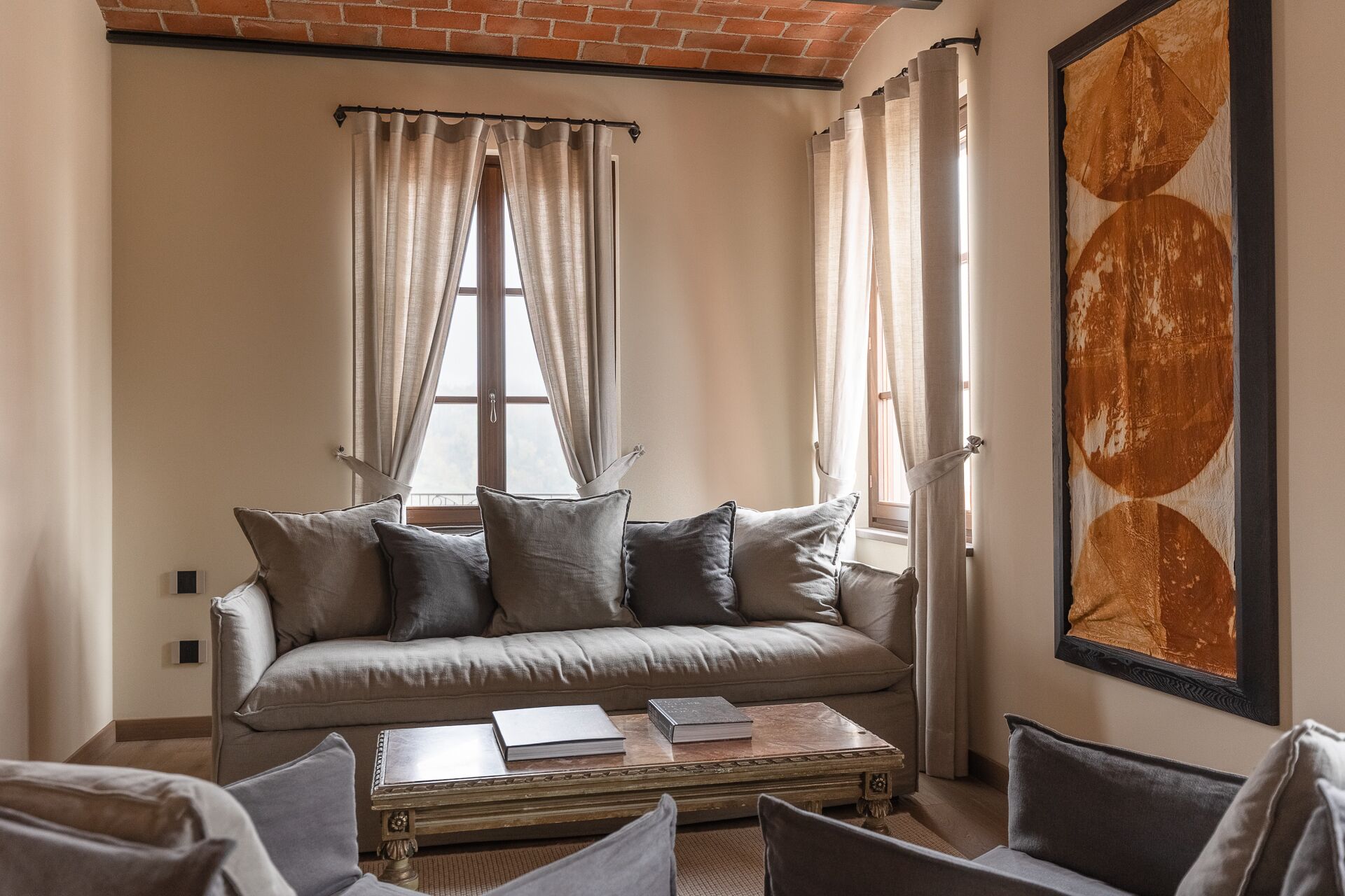 A living room with a sofa, a coffee table, and a large abstract painting on the wall.
