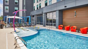 An indoor swimming pool with a poolside area, including lounge chairs and a poolside bar. - Aloft by Marriott Chattanooga Hamilton Place (Chattanooga)