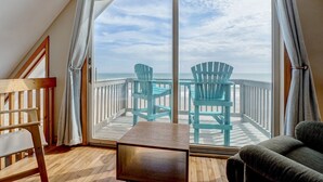 A balcony with two chairs and a table, overlooking a beach. - Oceanfront Getaway In Surf City (Surf City)