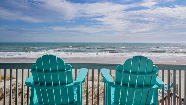 Two turquoise Adirondack chairs facing the ocean from a wooden deck. - Oceanfront Getaway In Surf City (Surf City)
