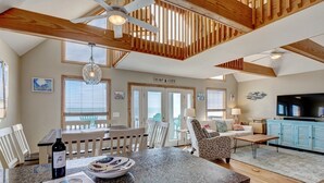 A spacious living area with a kitchen, dining area, and a balcony with a view. - Oceanfront Getaway In Surf City (Surf City)