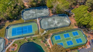 An aerial view of a sports complex with multiple tennis courts, a swimming pool, and surrounding greenery. - One of kind 3 bedroom Villa with Ocean/Lagoon Views. (Hilton Head Island)