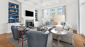 A living room with a fireplace, a television, and a sofa. - Penthouse in popular, centrally located new construction neighborhood (Kiawah Island)