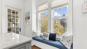 A kitchen with a built-in window seat, a white cabinet, and a view of the outside. - Penthouse in popular, centrally located new construction neighborhood (Kiawah Island)