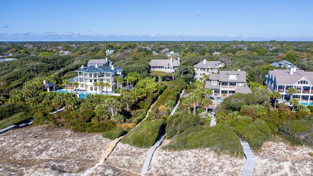 A coastal residential area with multiple large houses, a beach, and a boardwalk. - Beachside Treehouse, spectacular ocean view on popular Surfsong Rd (Kiawah Island)