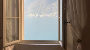 A room with a window overlooking a lake and mountains. - Villa Giudici Luxury app on the Lake (Nesso)