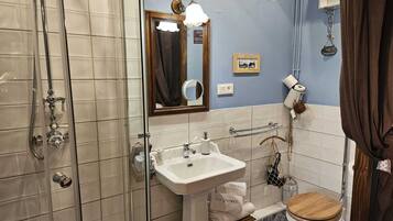 Une salle de bain avec une douche, un lavabo et des toilettes.