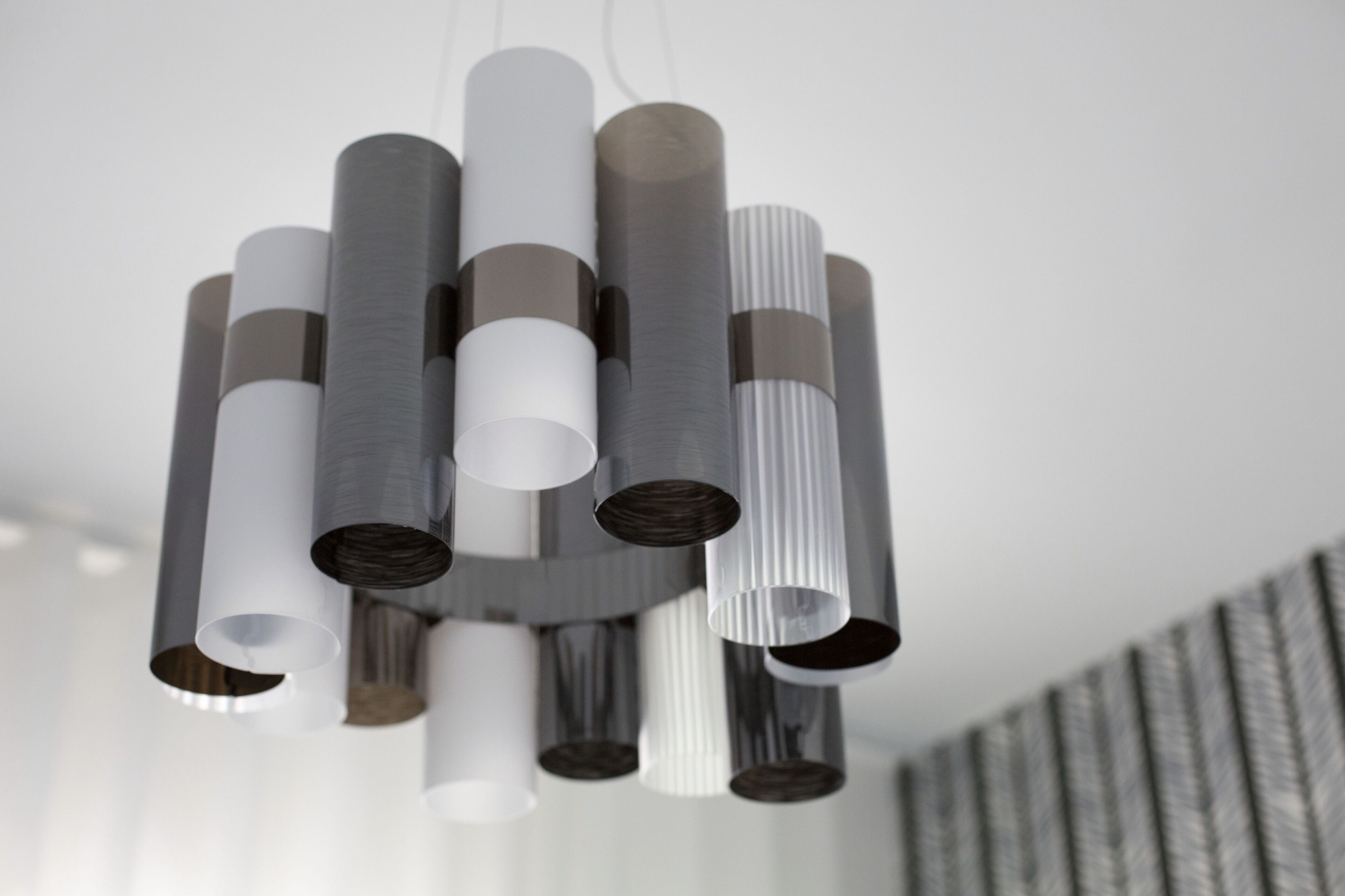 Un candelabro moderno con varias pantallas cilíndricas.